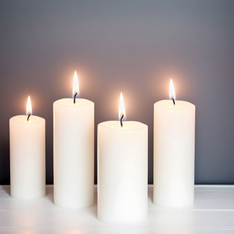 Elegant Illumination Harmonious Quartet Of White Candles Radiating Grace Against A Serene Gray Backdrop